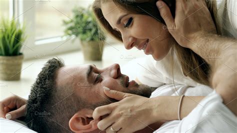 husband and wife in bed|Husband and wife having foreplay, kissing and hugging on bed, .